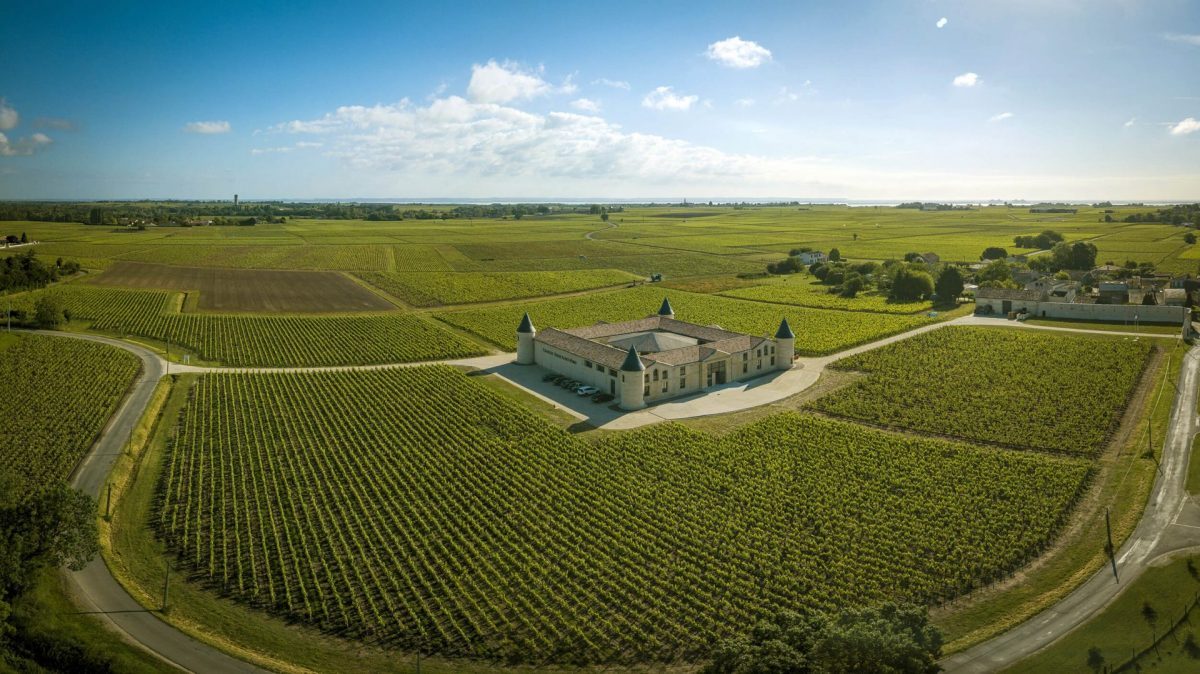 Château à tourelles entouré de vignes, au cœur du Médoc.
