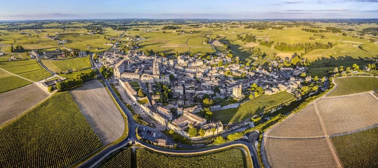 Vue aérienne du village médiéval de Saint-Émilion, entouré de vignes.